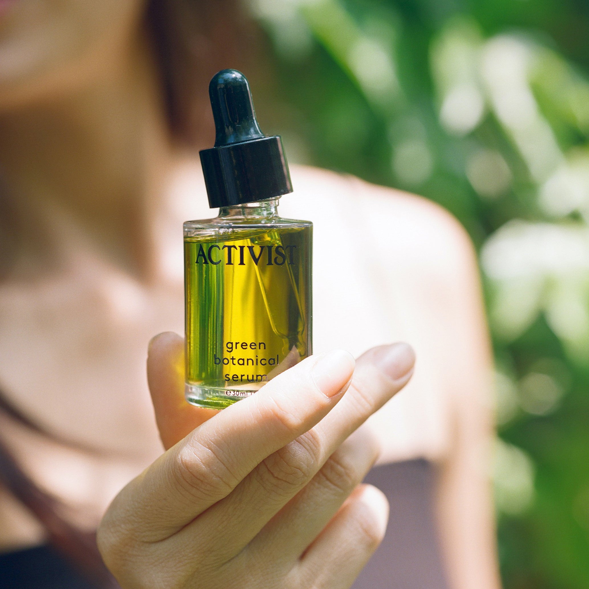 ACTIVIST Green Botanical Serum held in a person's hand